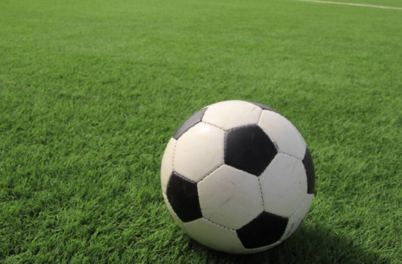 緑色の芝生の上にサッカーボールが置いてある画像